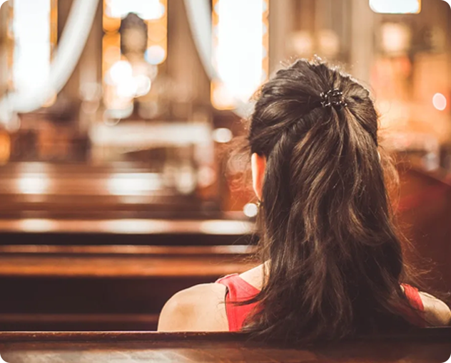 A woman sitting in the middle of a church.